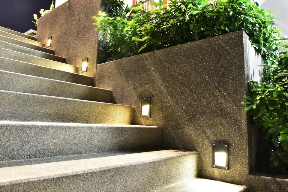 Escalier extérieur moderne en béton avec éclairage LED intégré dans les contremarches et mur de soutènement