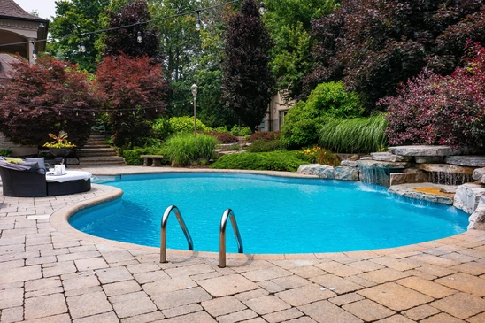 Piscine hors-sol ronde installée dans jardin résidentiel avec échelle d'accès, bouée flottante et système de filtration externe