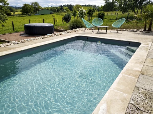Piscine hors-sol ronde installée dans jardin résidentiel avec échelle d'accès, bouée flottante et système de filtration externe